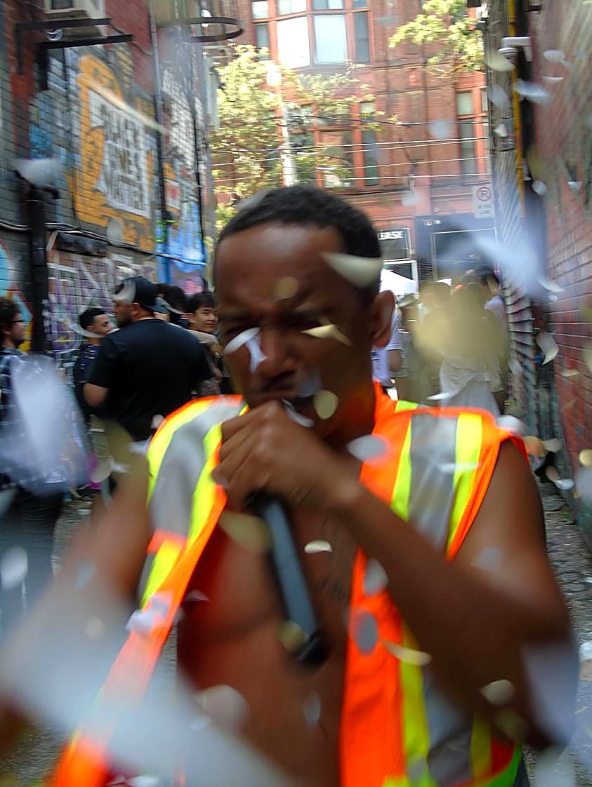 NoMatch singing into a microphone during a candid outdoor performance