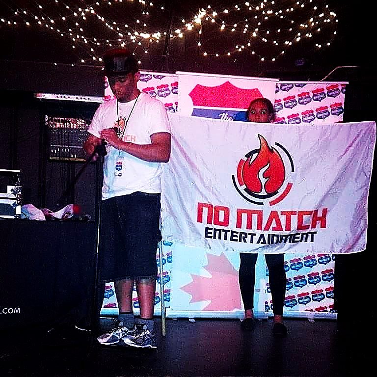 NoMatch performing on stage in front of a No Match Entertainment banner