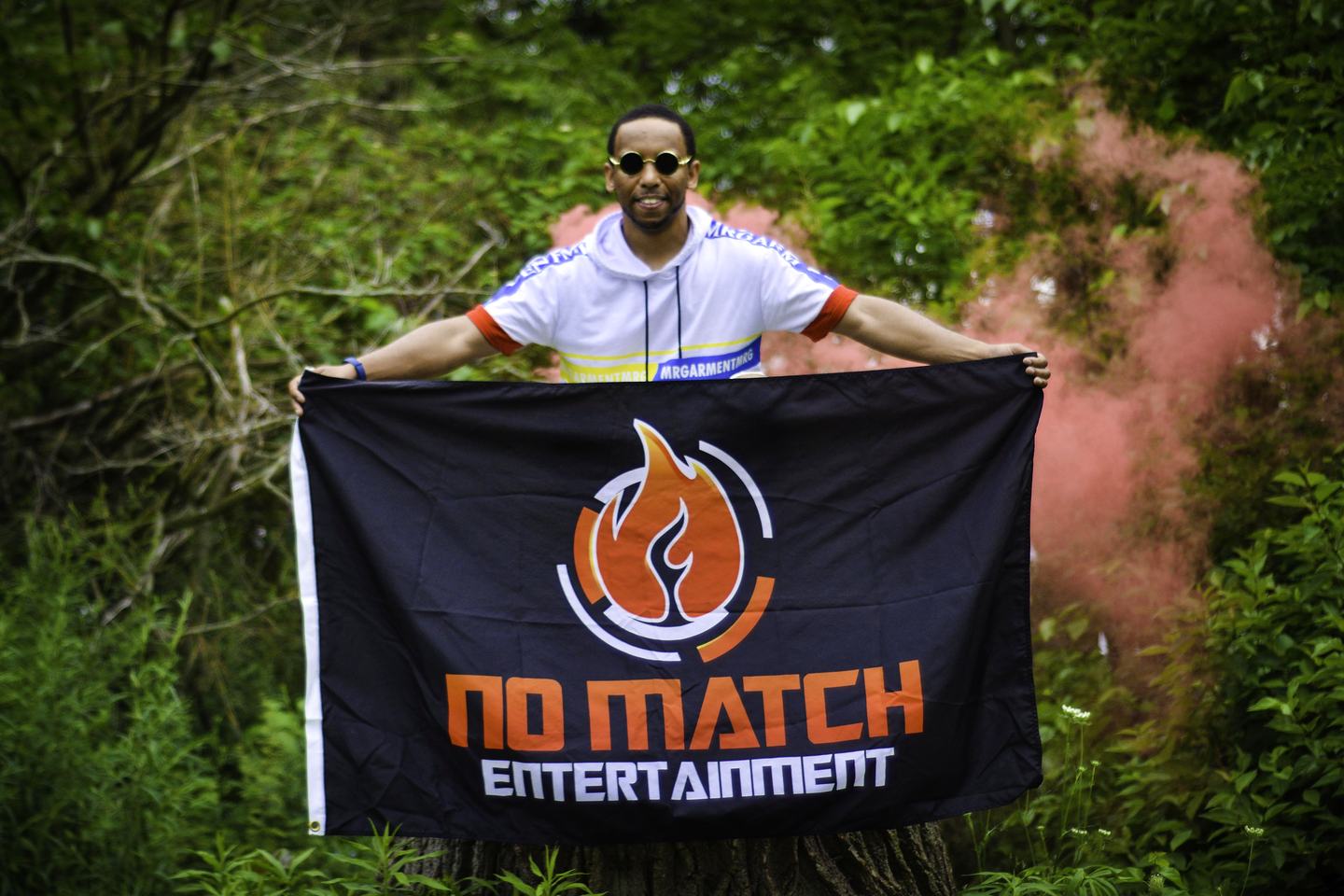 NoMatch holding a No Match Entertainment flag outdoors